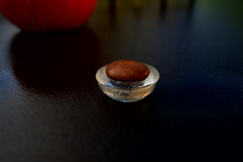 Stone capped tea-light holder on wet patio table at dawn. . . 